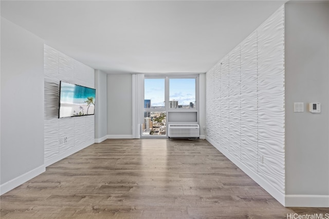 empty room with light hardwood / wood-style floors and a wall mounted air conditioner