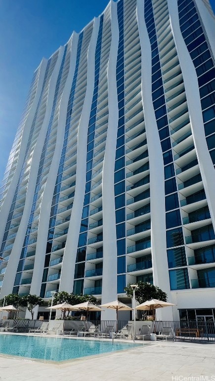 view of property featuring a community pool and ac unit