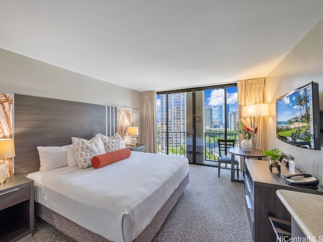 bedroom featuring dark carpet, a wall of windows, and access to outside