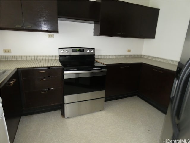 kitchen with light carpet, dark brown cabinetry, and stainless steel electric range oven