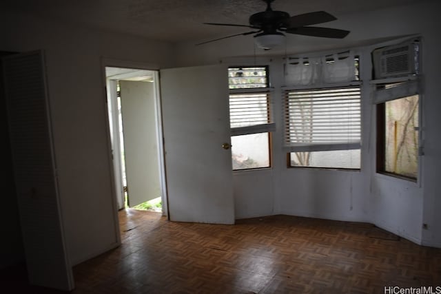 spare room with dark parquet floors and ceiling fan