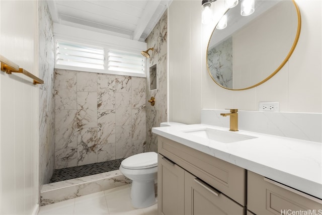 bathroom with toilet, vanity, and tiled shower