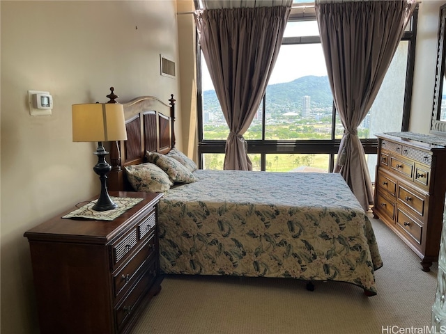 bedroom with a mountain view and light colored carpet