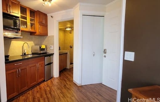 kitchen with sink, backsplash, ornamental molding, and dark hardwood / wood-style flooring