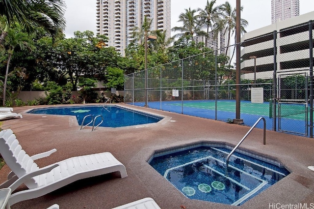 view of pool with a hot tub