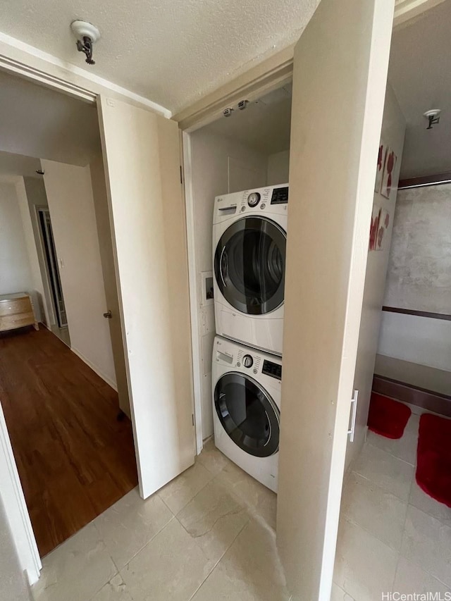 2499 Kapiolani Blvd Unit 3001, Honolulu, HI 96826 - clothes washing area with stacked washer / drying machine, a textured ceiling, light tile patterned flooring, and laundry area