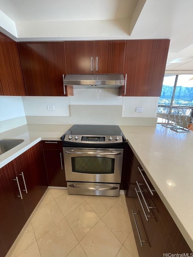2499 Kapiolani Blvd Unit 3001, Honolulu, HI 96826 - kitchen with stainless steel electric stove, a sink, light countertops, under cabinet range hood, and light tile patterned floors