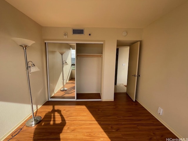 2499 Kapiolani Blvd Unit 3001, Honolulu, HI 96826 - unfurnished bedroom with baseboards, wood finished floors, visible vents, and a closet