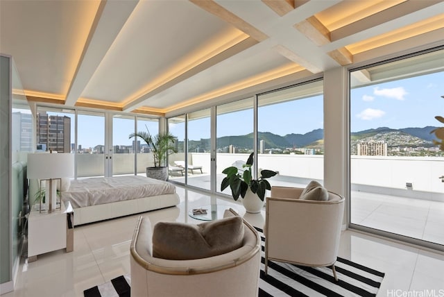 sunroom with a mountain view, french doors, and beam ceiling