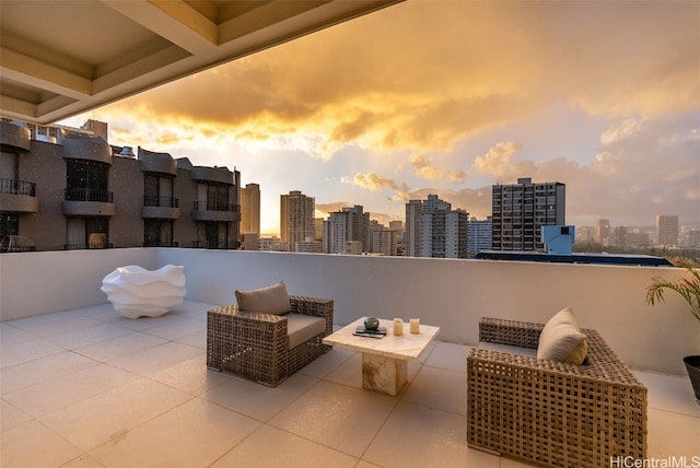 patio terrace at dusk featuring a balcony and an outdoor hangout area