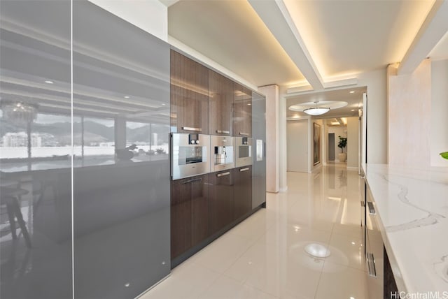 corridor with beam ceiling and light tile patterned floors