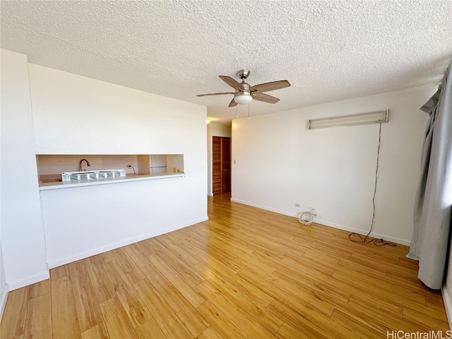 unfurnished living room featuring a textured ceiling, light hardwood / wood-style floors, and ceiling fan