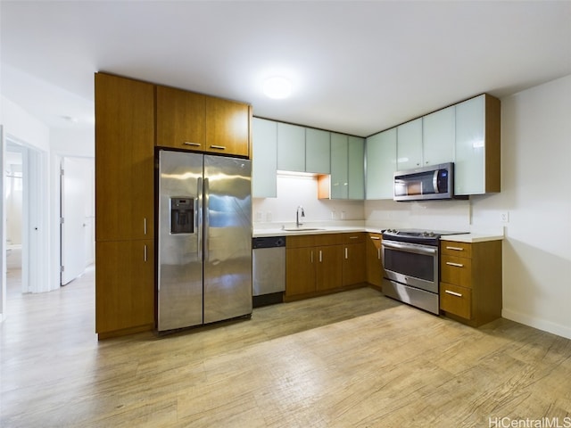 kitchen with light hardwood / wood-style flooring, appliances with stainless steel finishes, and sink