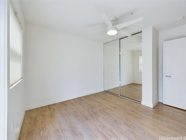 unfurnished bedroom featuring a closet, light wood-type flooring, and ceiling fan