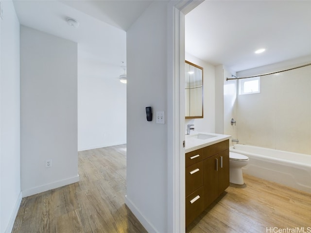 full bathroom featuring toilet, hardwood / wood-style flooring, vanity, and shower / bath combination