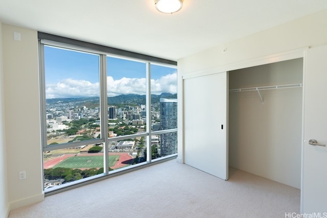 unfurnished bedroom featuring a closet and light carpet