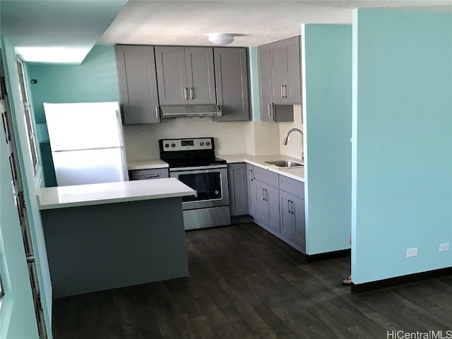 kitchen with dark wood-type flooring, gray cabinetry, sink, white fridge, and stainless steel electric range oven