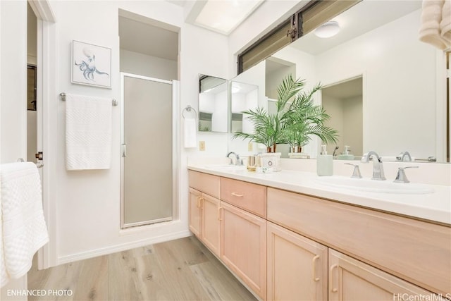 bathroom with hardwood / wood-style floors, vanity, and an enclosed shower