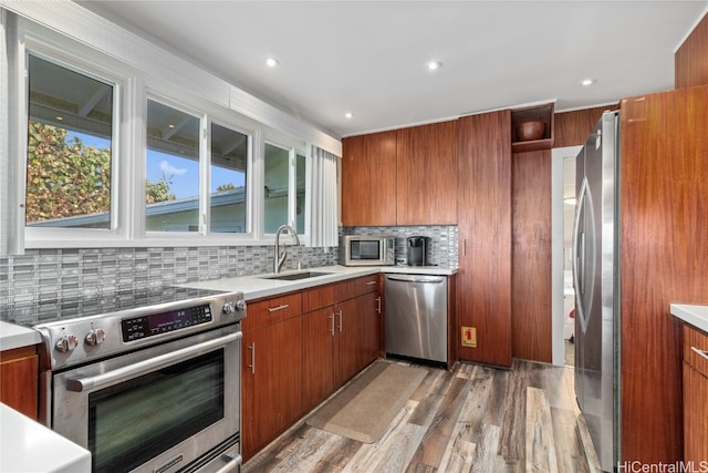 kitchen featuring tasteful backsplash, appliances with stainless steel finishes, sink, and light wood-type flooring