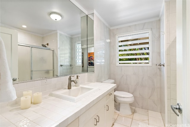 bathroom featuring a shower with shower door, toilet, tile walls, vanity, and crown molding