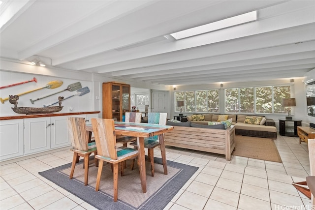 sunroom / solarium with beam ceiling and a skylight