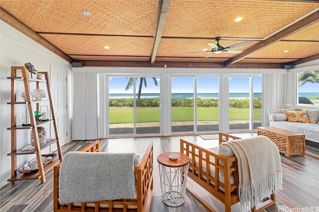 sunroom with a water view and ceiling fan