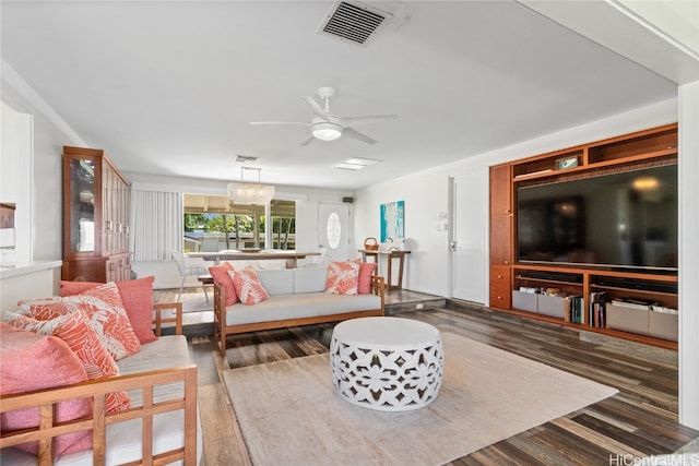 living room featuring dark hardwood / wood-style flooring and ceiling fan with notable chandelier