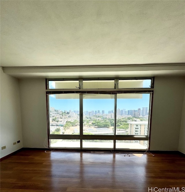 unfurnished room featuring a textured ceiling and dark hardwood / wood-style flooring