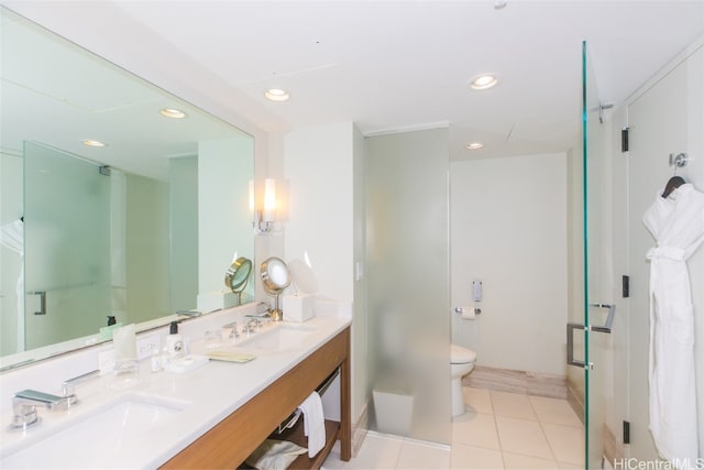 bathroom featuring toilet, a shower with shower door, vanity, and tile patterned floors