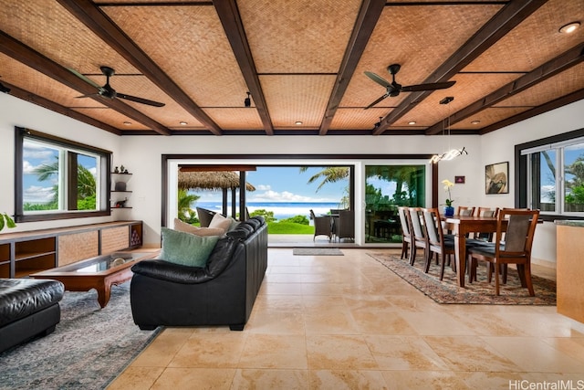 living room featuring ceiling fan, beamed ceiling, and plenty of natural light