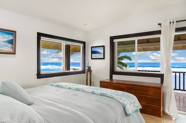 bedroom featuring a water view, lofted ceiling, and multiple windows