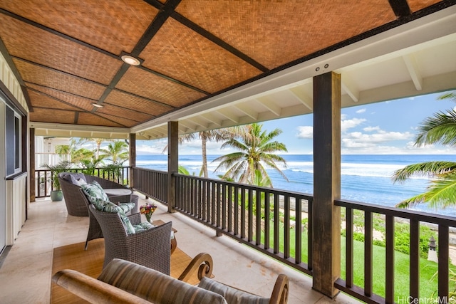 balcony with a water view and a view of the beach