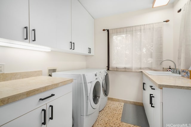 clothes washing area with independent washer and dryer, cabinets, and sink