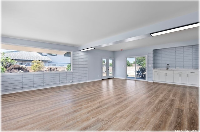 unfurnished living room featuring light hardwood / wood-style floors and sink