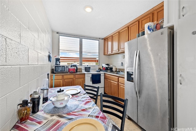 kitchen with backsplash, appliances with stainless steel finishes, and sink