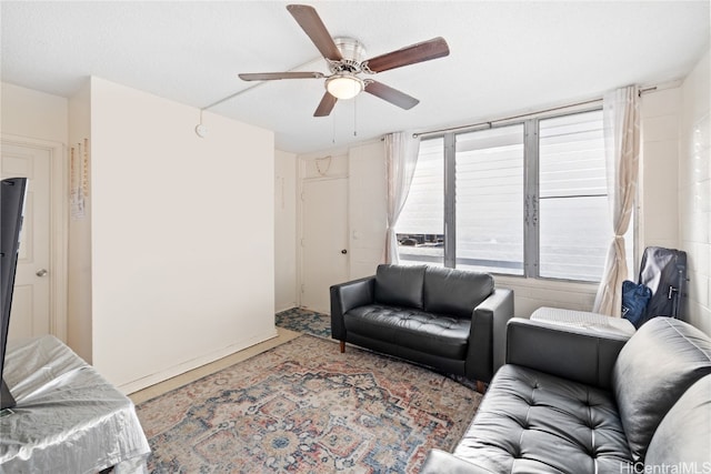 living room with ceiling fan and a textured ceiling