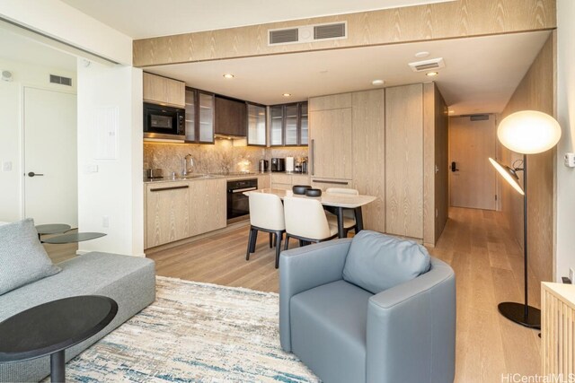 living room with light hardwood / wood-style floors and sink