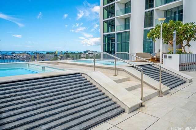 view of swimming pool with a hot tub and a patio