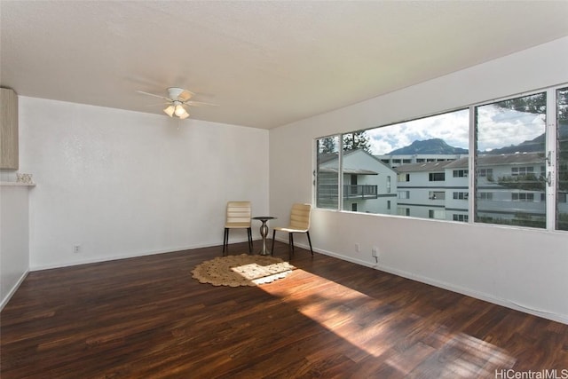 empty room with ceiling fan and dark wood-type flooring