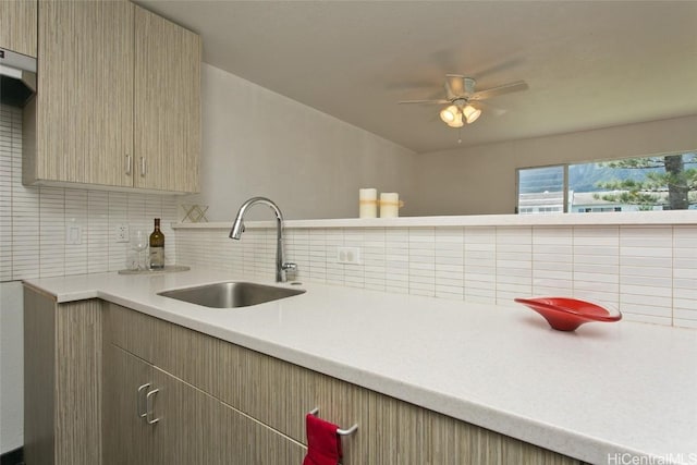 kitchen featuring decorative backsplash, ceiling fan, and sink