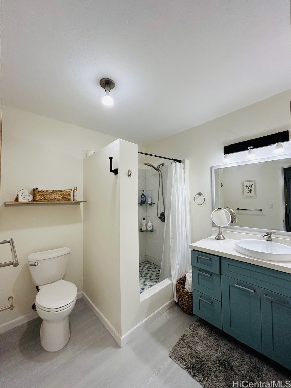 bathroom with curtained shower, vanity, hardwood / wood-style flooring, and toilet