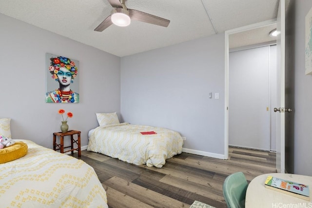 bedroom featuring a ceiling fan, baseboards, and dark wood-type flooring