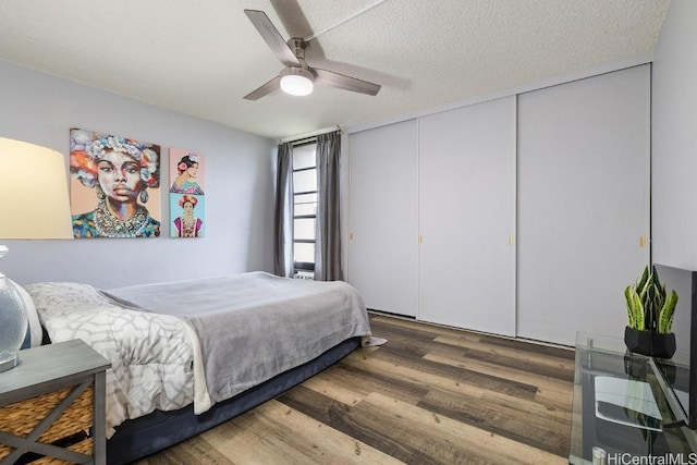 bedroom featuring dark wood-style floors, a closet, a textured ceiling, and a ceiling fan