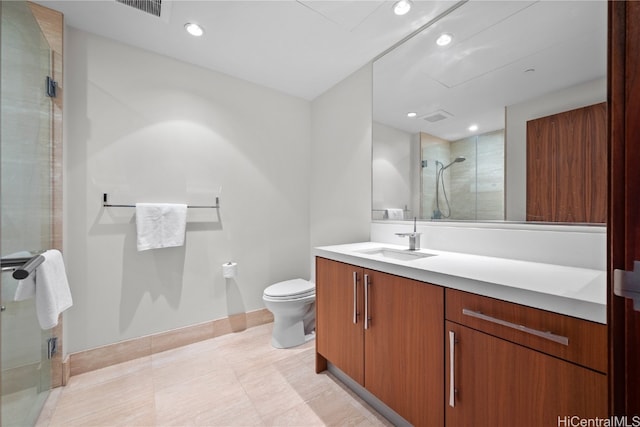 bathroom with a shower with door, vanity, and toilet