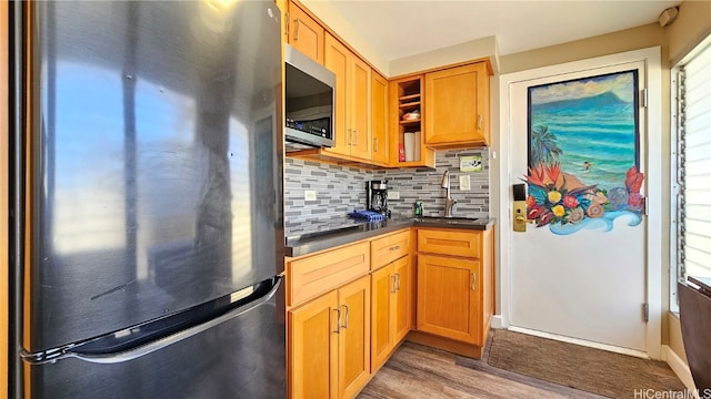 kitchen with appliances with stainless steel finishes, tasteful backsplash, sink, and dark hardwood / wood-style flooring