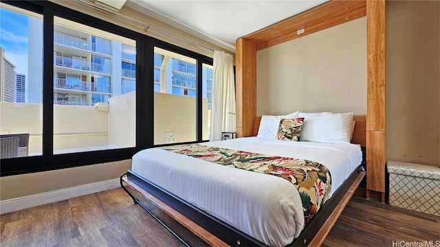 bedroom featuring ornamental molding and dark wood-type flooring