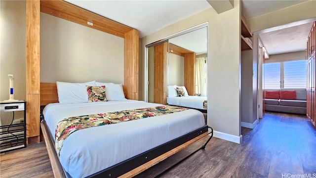 bedroom with dark wood-type flooring and a closet