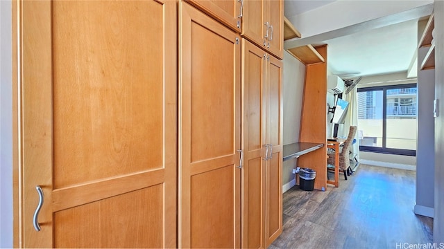 hallway featuring a wall mounted air conditioner and dark hardwood / wood-style floors