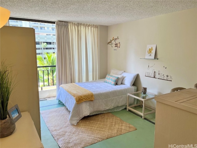 bedroom with expansive windows and a textured ceiling