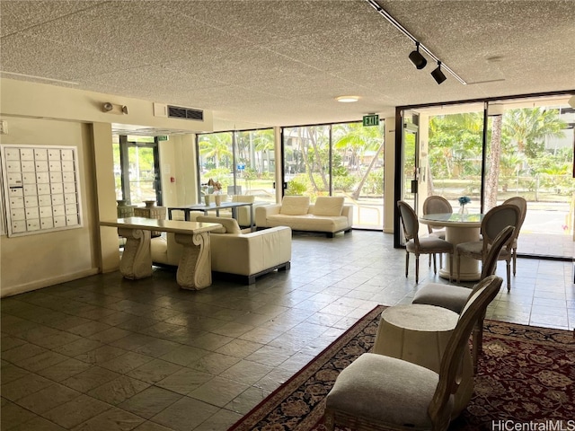 living room featuring a wall of windows and a mail area